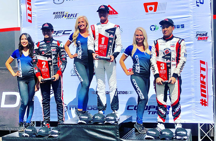 Calvin Ming stands on the third step of the podium following race one of the Cooper Tyres Mazda USF2000 series in Portland, Oregon. He was promoted to second after Igor Fragga (Extreme left) was handed a 30-second penalty.