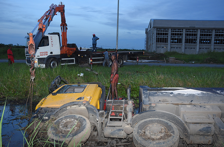 The City Trucking Service assists with the removal of the vehicle from a trench near Little Diamond on the East Bank of Demerara on Sunday (Samuel Maughn photo)