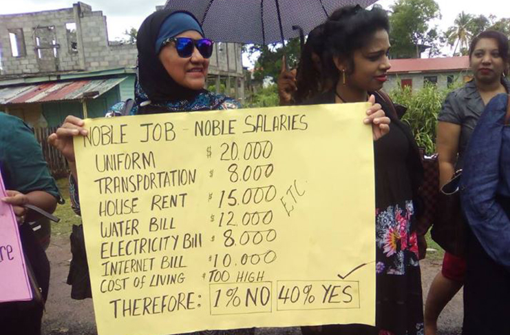 A teacher’s placard says it all outside of the Department of Education (DoE) in New Amsterdam