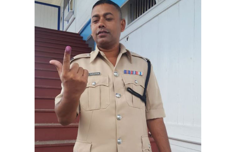 Commander of ‘G’ Division Khalid Pareshram shows off his inked index finger after casting his vote