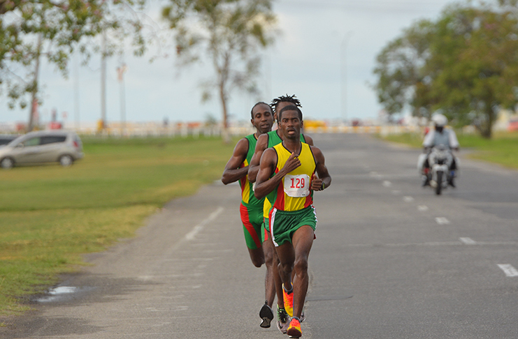 : MAKING A MOVE! Cleveland Forde takes the lead ahead of Winston Missigher and Cleveland Thomas after passing them just after the 8K mark on the JB Lachmansingh Road. (Samuel Maughn photos)