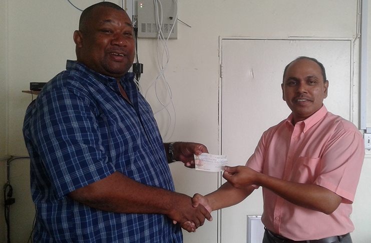 BCB president Hilbert Foster receives the sponsorship cheque from Chandradat Chintamani.