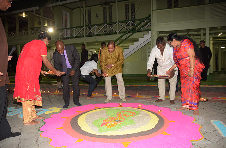 Acting Prime Minister, Vice President Carl Greenidge; Acting President, Prime Minister Moses Nagamootoo and his wife Mrs Sita Nagamootoo placing diyas on the Rangoli at the State House