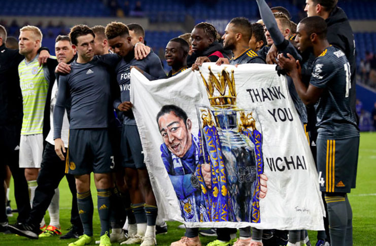 The Leicester City team hold up a tribute banner to the club's late owner Vichai Srivaddhanaprabha, who died in a helicopter crash. (Photograph: Richard Heathcote/Getty Images)