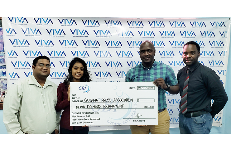 Guyana Beverage Inc.’s Shaundel Haripersad makes a presentation to GPA executive member Rawle Toney to mark her company’s sponsorship of the VIVA Inter-Media Domino Tournament. Also in photo, Raymond Gavinda, VIVA Brand Manager (first from left) and SannSports’ Esan Griffith.