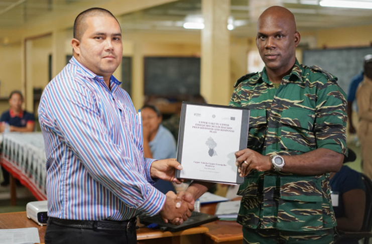 Director-General of the Civil Defence Commission (ag), Lieutenant-Colonel Kester Craig hands over the draft Regional Multi-Hazard Preparedness and Response Plan for Region Nine to Vice-Chairman Mr. Karl Singh