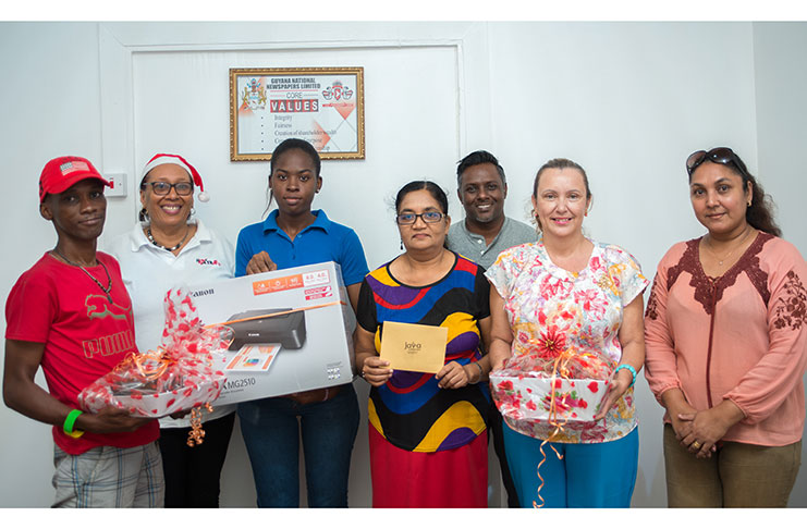 Administrative staff of the Guyana Chronicle pose with the winners of the company’s Christmas giveaway