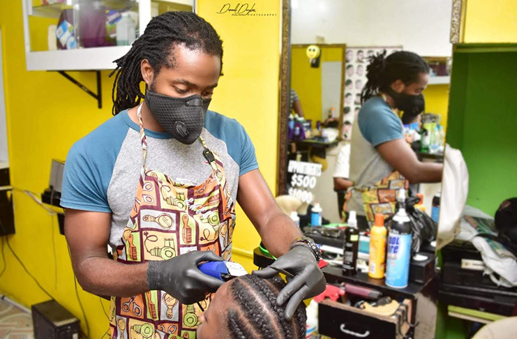 Emmette Albert grooming
customers at his barber shop