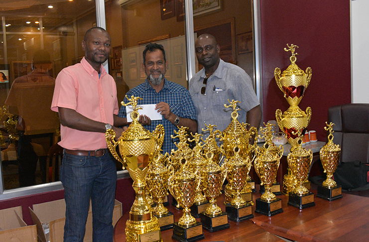 Mohamed’s Enterprise proprietor Nazar Mohamed hands an undisclosed sum and trophies to GFF Executive Committee Member Dion Innis and Aubrey ‘Shanghai’ Major.