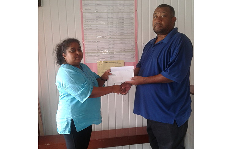 Priya Rampersaud of Sentinel Security hands over cheque to Hilbert Foster.