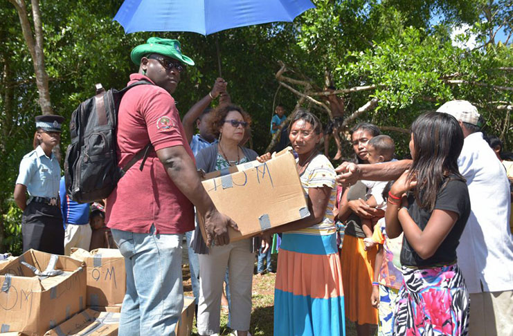 Minister within the Ministry of Indigenous Peoples’ Affairs Valerie Garrido-Lowe and Major Sean Welcome distributing hampers to migrant families (DPI photo)