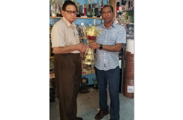 Proprietor Ramesh Sunich (right) presents one of the trophies to Justice Cecil Kennard.