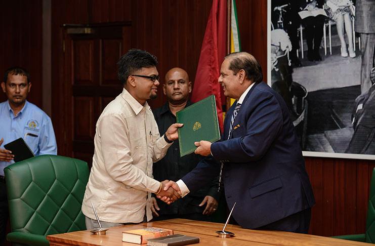 Acting President and Prime Minister Moses Nagamootoo presenting Mayor of Georgetown Pandit Ubraj Narine with his credentials