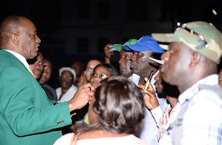 Minister of State, Joseph Harmon reassuring supporters outside the Public Buildings
