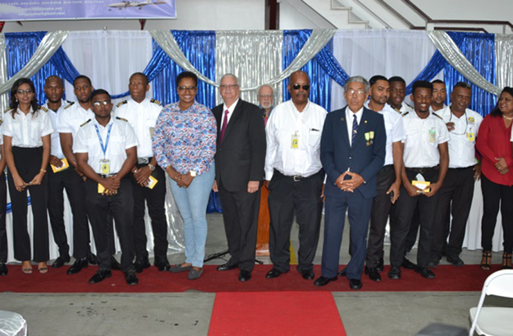 [In the photo, sixth from left] Minister within the Ministry of Public Infrastructure, Annette Ferguson; Director of Aviation SAFETY Regulations of the Guyana Civil Aviation Authority, Captain Christopher Kirkcaldy; Chairman AWHWAES and CEO Fly Jamaica, Captain Ronald Reece; and Director of the Art Williams and Harry Wendt Aeronautical Engineering School, Captain Malcolm Chan-A-Sue; Master of Ceremonies Kit Nascimento [in the back] along with some of the graduates