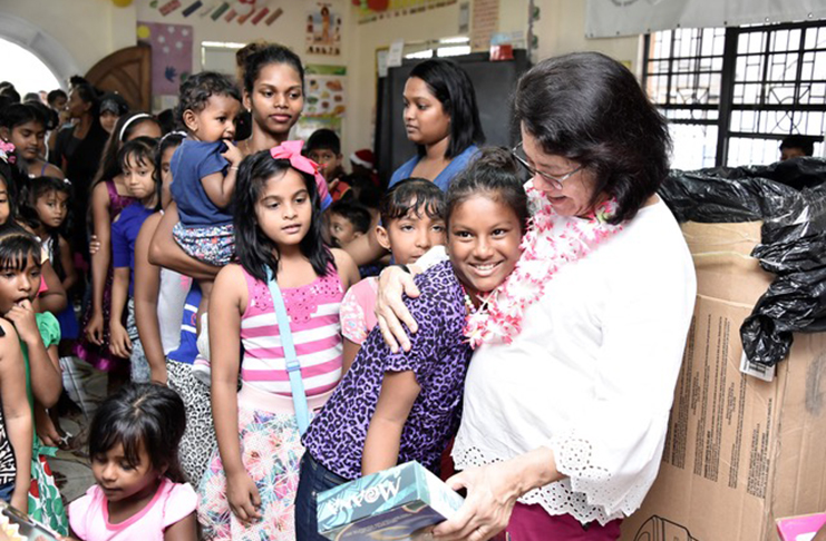 First Lady Sandra Granger embraced this child as she spread Christmas cheer along the East Coast of Demerara on Saturday
(Ministry of the Presidency photo)