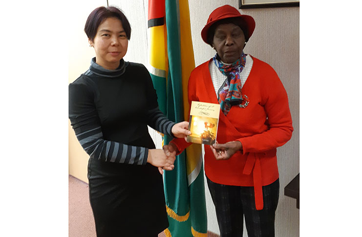 Thelma Tappin (right) hands over a copy of her book to Guyana’s Consul General to Toronto, Anyin Choo
