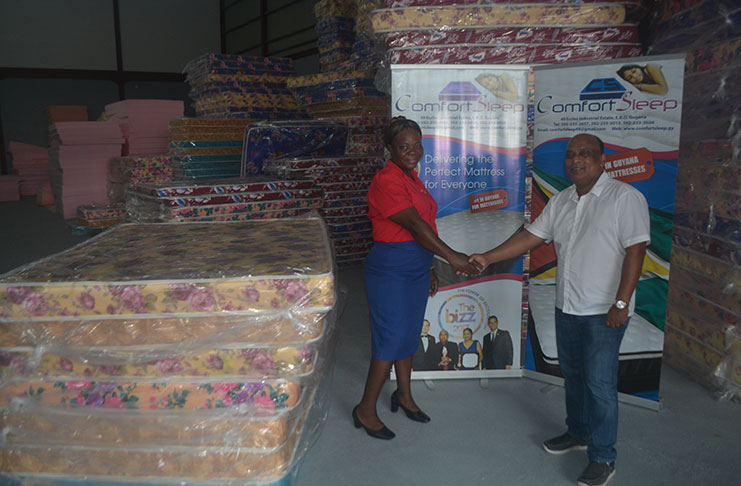 Head teacher of Victoria Primary School, Althea Russell receives the donation from Managing Director of Comfort Sleep, Dennis Charran