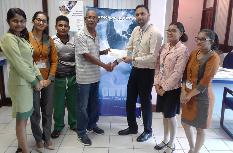GBTI branch manager Ghoeblall Mahadeo hands over sponsorship to RHTY&SC cricket manager Robby Kissoonlall as Simon Naidu and GBTI staff look on.