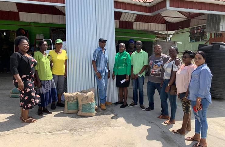 Minister Valerie Adams-Yearwood (centre) making the presentation to Oscar Anthony (immediate left) and Miss Roslyn Gordon (second left) of the zinc sheets and cement. Adams in flanked by several PNCR executive members in Linden and LMTC councillors