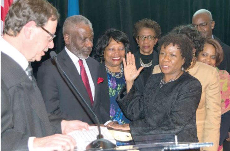 Hon. Ingrid Joseph, surrounded by family members, is sworn in as a justice of the Kings County Supreme Court by Hon. Mark Partnow (left) during a ceremony at St. Francis College. (Brooklyn Daily Eagle photo)