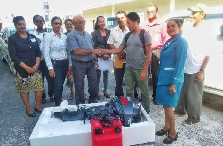 Regional Executive Officer (REO) Denis Jaikaran and a regional administration team [left], hand over the outboard engine