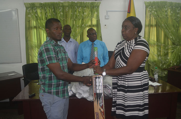 Chairman of the Region 10 RDC’s Education Committee Denise Belgrave handing over a quantity of cricket gear to Ituni CDC Chairman, Kurt Murphy, in the presence of Regional Chairman Renis Morian and Deputy Regional Chairman, Elroy Adolph.