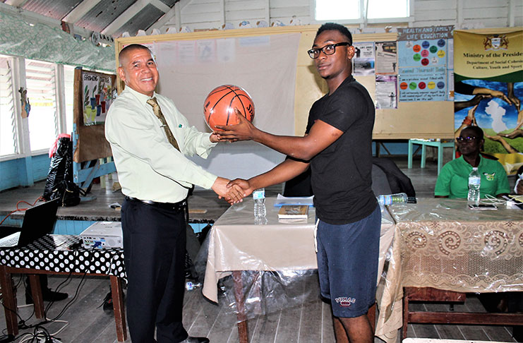 One of Ithaca’s basketball players receiving a ball from the Hon. Minister of Social Cohesion, Culture, Youth and Sport, Dr. George Norton