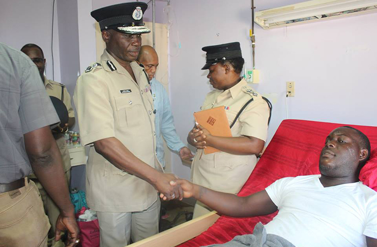 Top Cop Leslie James interacts with injured police officer, Constable Mark Grimmond (GPF photo)