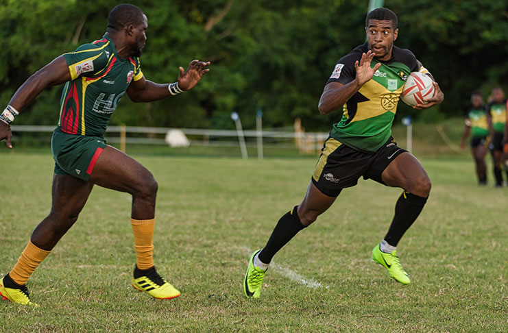 Guyana’s Avery Corbin (left) about to tackle his Jamaican counterpart during the last RAN 7s Championship.