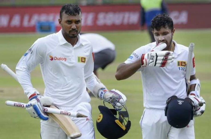 Sri Lanka's Oshada Fernando (L) and Kusal Mendis walk back to the pavilion after victory in the second Test cricket match against South Africa.