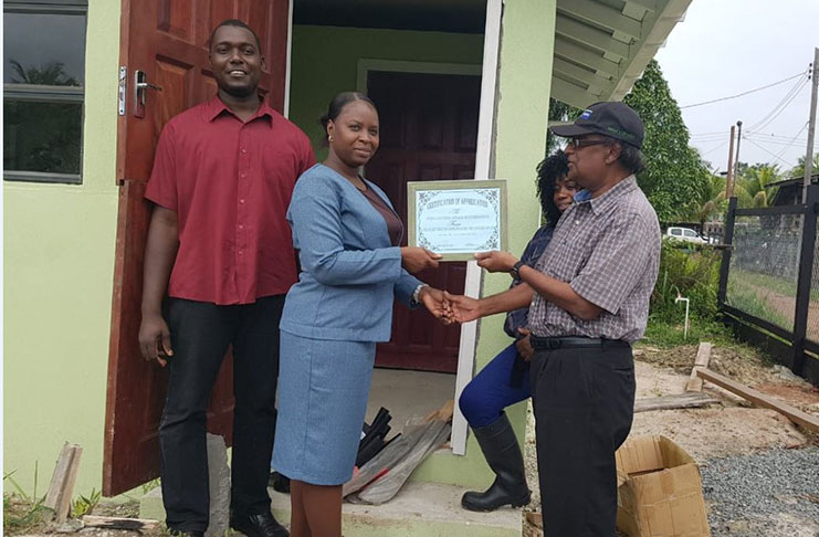 Dr Homenauth receiving the certificate of appreciation from one of the group members