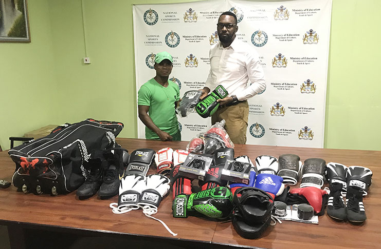 Orlando Rogers (Left), coach of the Pocket Rocket Gym in Linden, receiving a quantity of boxing gear from Director of Sports, Christopher Jones.