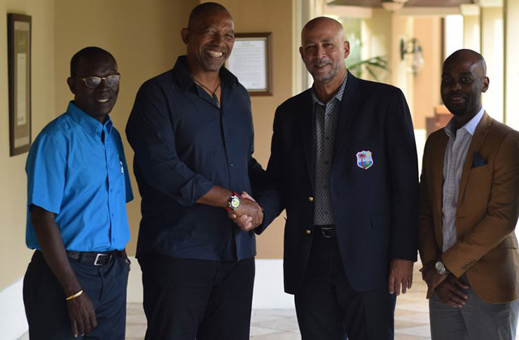 Ricky Skerritt (second from right) shakes hands with former West Indies coach Phil Simmons. Looking on is CWI director Enoch Lewis (left) along with CWI vice-president Dr Kishore Shallow.
