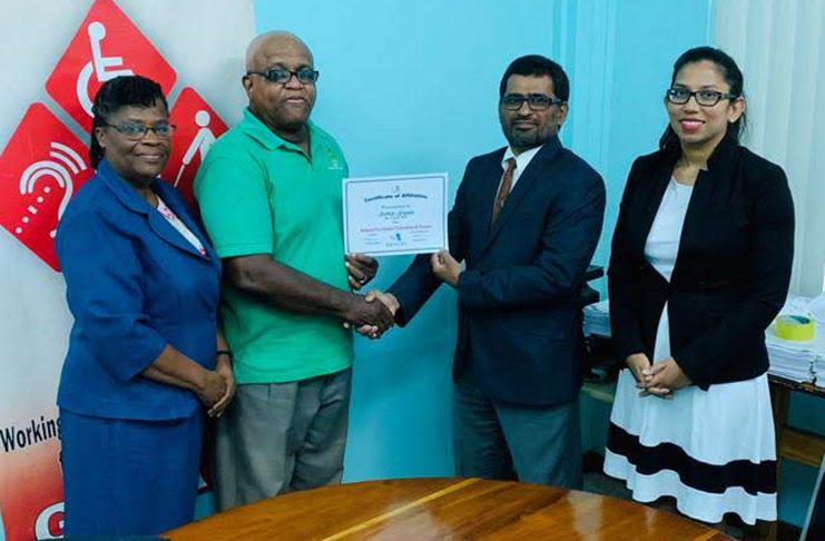 Archery Guyana president Mohamed Khan receives Certificate of Affiliation from National Paralympic Committee of Guyana’s president Wilton Spencer. Looking on are the respective secretary-generals Beverly Pile and Vidushi Persaud-McKinnon.