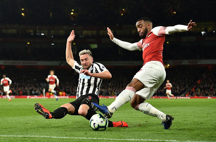 Newcastle United's Welsh defender Paul Dummett (left) blocks a cross from Arsenal's French striker Alexandre Lacazette. – (AFP)