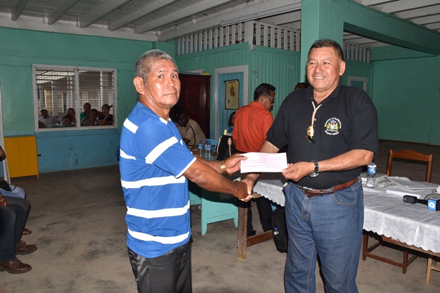 Parakese Senior Councillor, Terrence Edwards receiving a cheque from Minister of Indigenous Peoples’ Affairs, Sydney Allicock. (DPI photo)