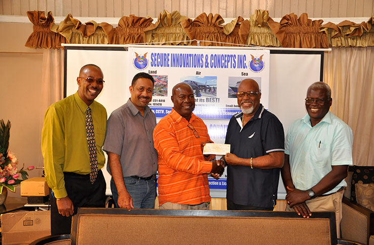 Managing Director of Secure Innovations & Concepts Inc.,  Harold Hopkinson (2nd right) hands over cheque to Lennox Braithwaite in the presence of, from right,  Colonel Enoch Gaskin, Fullbore vice- captain Dylan Fields and secretary Ryan Sampson.