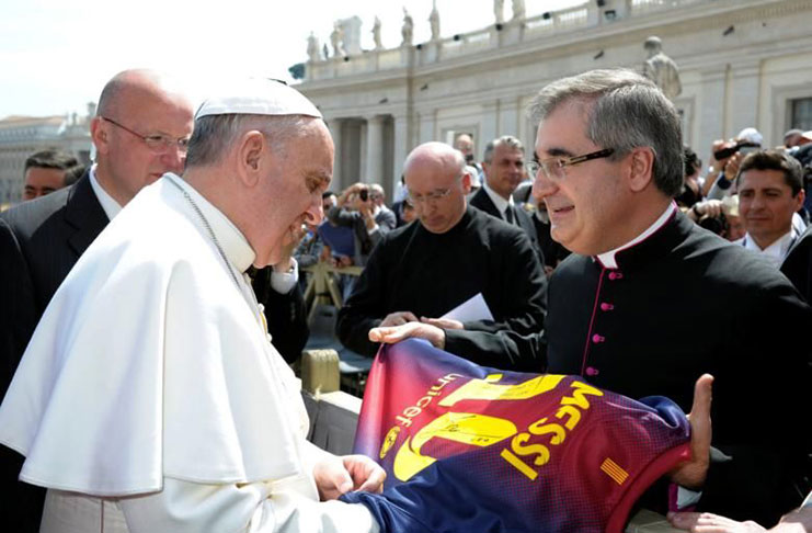 Pope Francis receives a Barcelona soccer jersey of player Lionel Messi during the weekly audience in Saint Peter's Square at the Vatican April 17, 2013. REUTERS/Osservatore Romano