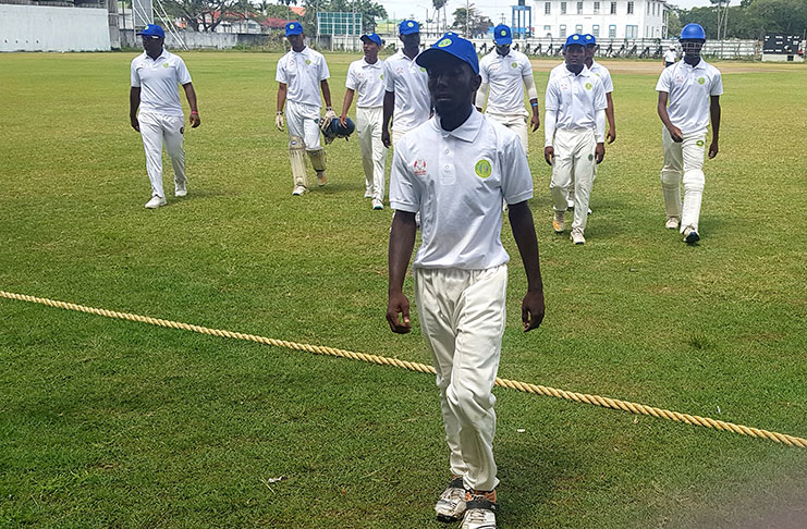 Joel Spooner leads Demerara players off the field after he claimed 5-10.