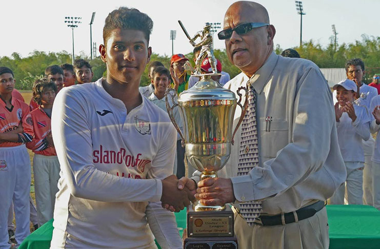 TT Under-15 player Justin Jagessar, left, collects a trophy from TT Cricket Board president Azim Bassarath, after leading the Central Zone to the U-15 Inter Zone title earlier this year. Jagessar scored 73 on Saturday against Guyana in the Regional U-15 tournament. (PHOTO COURTESY TTCB)