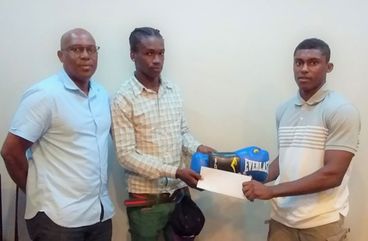 Boxer Jamal Eastman (centre) receives a pair of Everlast gloves and a cheque from Darren Elcock in the presence of GBA president Steve Ninvalle. (Newsroom photo)