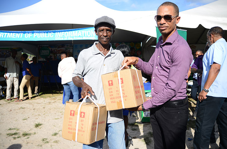APNU Campaign Member Damuka Ngqondo (right) hands over two sewing machines to Godfrey Day on behalf of the Ministry of Social Protection (Samuel Maughn photo)