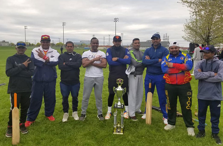 Members of Assassins pose with the winners’ trophy following their victory.