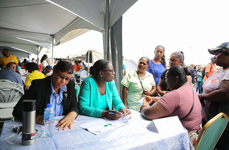 Minister of Education, Dr. Nicolette Henry interacting with several sweeper/cleaners of CV Nunes Primary School    