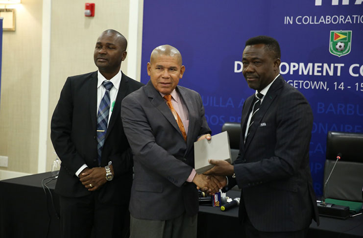 A token of appreciation! FIFA’s Director of Member Associations and Development, Veron Mosengo-Omba (first from right), makes a presentation to Minister of Social Cohesion, Dr George Norton. Also in photo is GFF president Wayne Forde (first from left). (Photo compliments: DPI/Keno George)