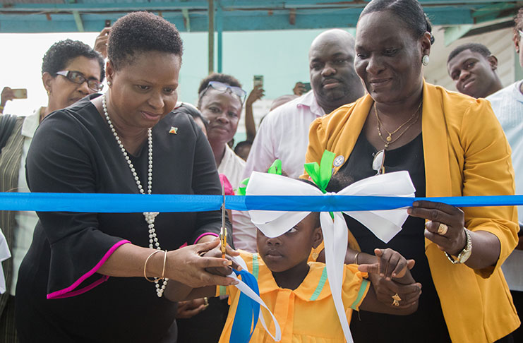 Minister of Public Health, Volda Lawrence, cuts the ceremonial ribbon with assistance from Senior Nursing Tutor, Oslene Hicken-Paul