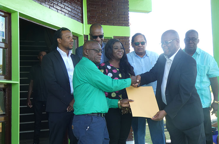 NCN Chairman, Enrico Woolford handing over some legal documents to LBN Chairman, Renis Morian. Also in photo are Prime Minister Moses Nagamootoo, former Minister of State, Joseph Harmon, and Jermaine Figueira, MP