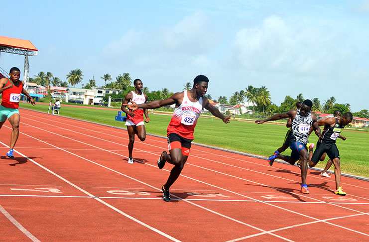 Emmanuel Archibald (centre) celebrates as he crosses the finish line ahead of Winston George (2nd from right) and Rupert Perry (right) to cop gold in the Men’s 100m at the NTFC, Leonora, West Coast Demerara. (Adrian Narine photos)