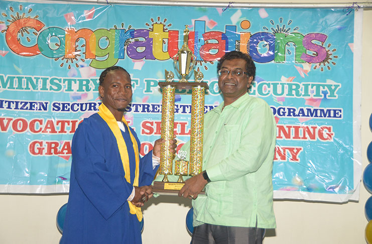 Minister of Public Security, Khemraj Ramjattan presents the best graduating student award to valedictorian, Joel Primo (Adrian Narine photo)